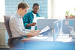 © pressmaster - Serious young financier reading papers by individual workplace in working environment