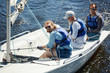 © pressmaster - Company of active men in lifejackets sitting in yacht during their summer voyage