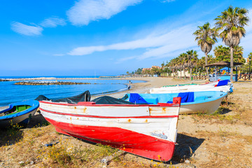 Typical white and red color fishing boat on beautiful beach near Marbella, Andalusia, Spain