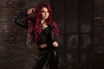 redhead adult girl biker in the leather wear indoor