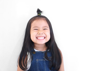 Asian children cute or kid girl and kindergarten student happy smile white teeth and laugh with wear dungarees jean for fashion on white background with space isolated