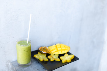 Mango and carambola on plate, kiwi green fresh juice Concept of fruits and healthy food.