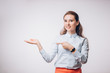 © liliyabatyrova - Young brunette business woman presents the product, shows her hand to the empty space,