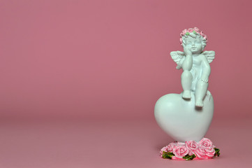 Wall Mural - Angel and heart decoration on pink background with copy space. Love concept  