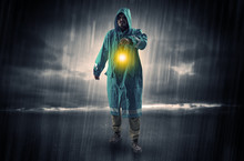 Raincoated Man Walking In Storm With Glowing Lantern In His Hand
