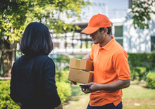Delivery Man In Orange Is Handing Packages To A Woman