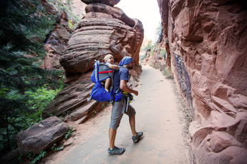 Wall Mural - A man with his baby boy are trekking in Zion national park, Utah, USA