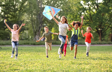 cute little children playing with kite outdoors on sunny day