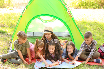 Wall Mural - little children with map near tent outdoors. summer camp