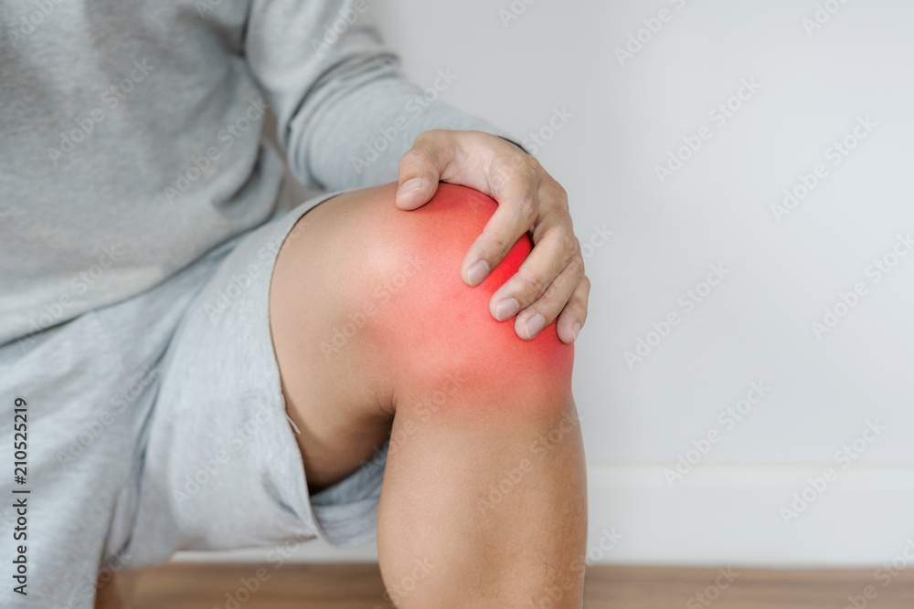 a man touching knee with red highlights concept of knee and joint pain - obrazy, fototapety, plakaty 