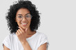 © wayhome.studio  - Positive African American female smiles broadly, holds chin, being self confident, presents project work in front of colleagues, wears glasses, isolated over white background. People, ethnicity