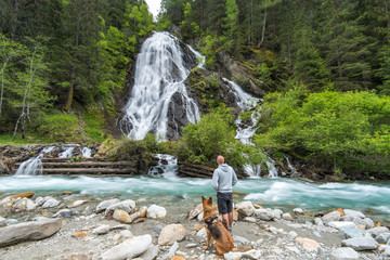 Sticker - Man with dog looking at Staniskabach waterfall near Glossglockner in Austria Alps