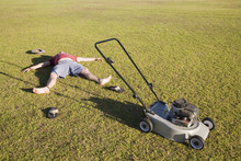 An Exhausted Man Lying On The Ground Collapsed After Mowing A Huge Lawn.