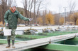 © JackF - Female feeding fish on sturgeon farm