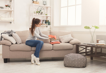 Woman folding clean t-shirts at home