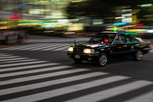 Black Taxi Rushing In The Streest Of Tokyo At Night  With Motion Blur Effect