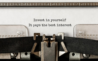 Wall Mural - Text Invest in yourself, it pays the best interest typed on retro typewriter