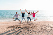 © ManuPadilla - Group of happy young people jumping at the beach on beautiful summer sunset. Four best men friends. Friends and holiday concept