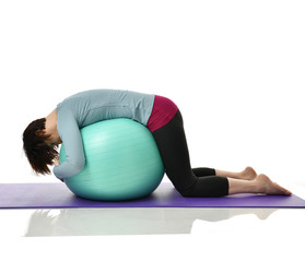 Mother woman exercising doing postnatal workout. Female fitness instructor holds legs in gym and workout exercises for abdominals with green sport ball over white 