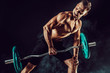 © zamuruev - Strong athletic man pumping up muscles workout bodybuilding. muscular bodybuilder handsome men doing exercise for muscles of back with a barbell on dark background with smoke. Strength and motivation.