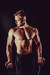 © zamuruev - Fitness man exercising with stretching band. Muscular sports man exercising with elastic rubber band. Guy working out with rubber band. Fit, fitness, exercise, workout and healthy lifestyle
