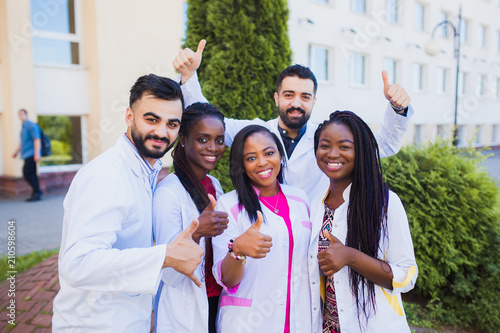 Fotografia, Obraz Group of cheerful African friends giving thumbs up