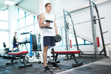 Full Length Portrait Of Handsome Muscular Man With Prosthetic Leg Working Out With Weights  In Modern Gym, Copy Space