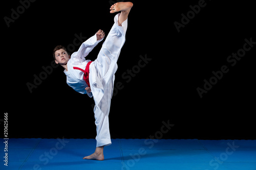 Fototapeta Karate  mlody-chlopak-ubrany-w-biale-kimono-karate-z-czerwonym-pasem