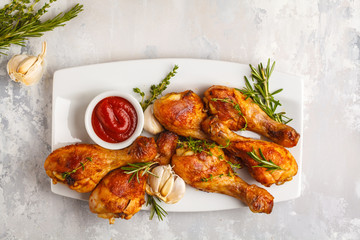 Wall Mural - Grilled spicy chicken legs baked with garlic, rosemary and thyme on white background.