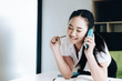 © Jirapong - Asia business accounting concept, woman using  smart phone calling to client and holding pen in office.