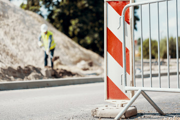 Wall Mural - Red and white road sign and railing on the street during roadworks