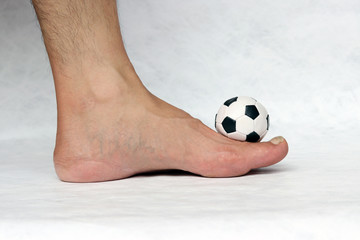 Mini ball of football on the foot with white background. Concept of sport.