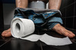 Man suffers from diarrhea is sitting on toilet bowl