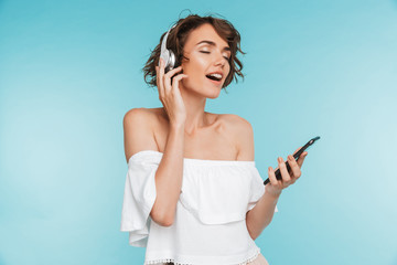 Poster - Portrait of a delighted young woman listening to music