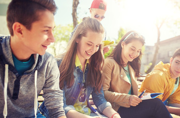 Poster - education, high school and people concept - group of happy teenage students with notebooks learning at campus yard