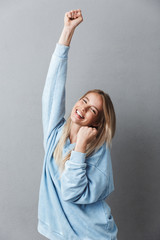 Poster - Portrait of an excited young blonde girl celebrating