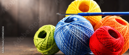 Fotografía Colorful yarn for crocheting and hook on wooden table