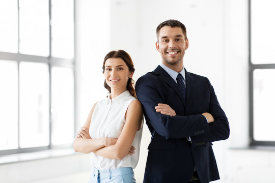 business, people and corporate concept - happy smiling businesswoman and businessman at office