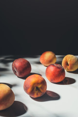 food composition with fresh peaches on light marble surface with black background