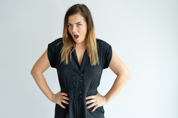 Sticker - Angry woman shouting and holding hands on hips. Lady looking at camera. Indignation concept. Isolated front view on white background.