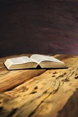 Bible on a old oak wooden table. Beautiful dark background.Religion concept