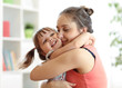 © Oksana Kuzmina - love and family concept - happy mother and child daughter hugging at home