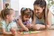 © Oksana Kuzmina - Mom and her children playing in ludo board game