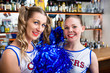 Two cheerleader girls in sports bar waiting for game to start