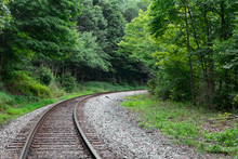 Train Tracks Lead Into A Curve Or Bend In The Forest Of West Virginia.