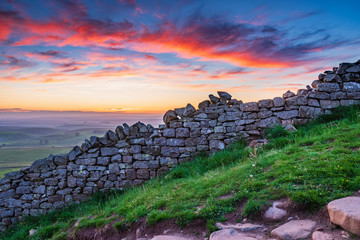 Wall Mural - red clouds above hadrian's wall / hadrian's wall is a world heritage site in the beautiful northumbe