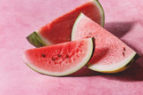Ripe sliced watermelon over pink texture background.