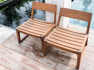 Double wooden chair on the plank floor.