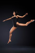 © Mike Orlov - Beautiful young and fit ballet dancer jumping on a black background. Dance and sport concept.