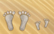 Kleine und große Füße aus Stein im Sand